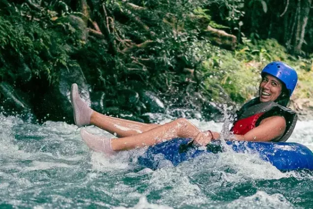 A woman riding a tube down a river.