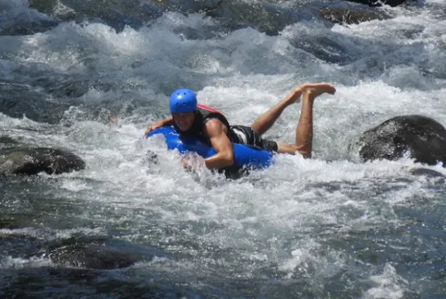 A man is floating down a river on a raft.