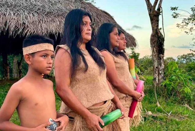 Indigenous people wearing traditional Nike clothing standing outdoors.