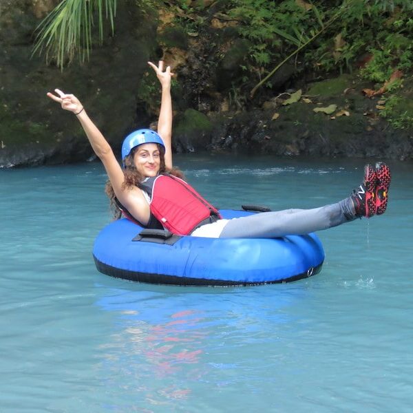 Tubing rio celeste A girl on a tube on the Rio Celeste, rising her arms.