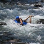 a man tubing down on rio celeste river rapids