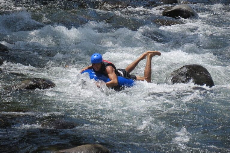 a man tubing down on rio celeste river rapids