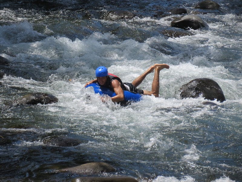 A man practicingTubing on the rapids ofrio celeste