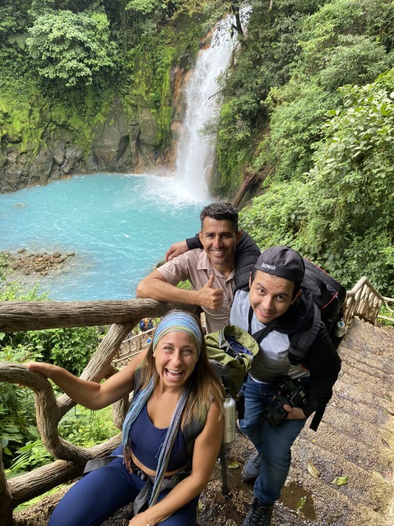 A group of friends having behind the Rio Celeste Waterfall