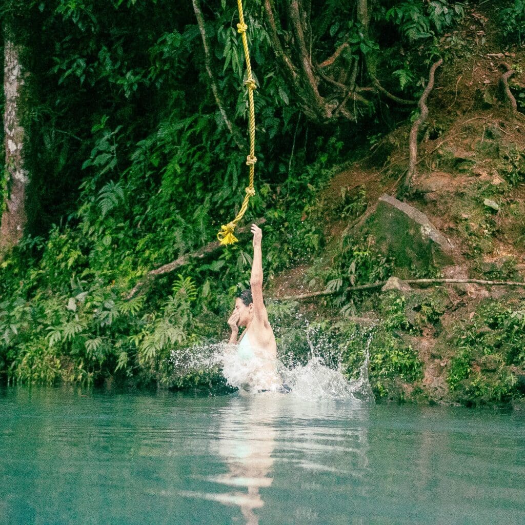 A beautiful girl diving in the end of the tubing tour in Rio Celeste by Onca Tours