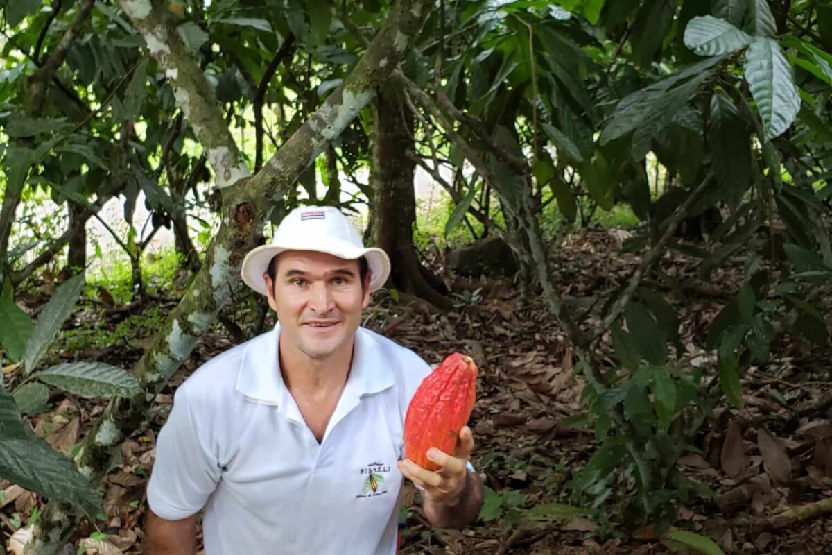 A men holding a cacao bean in his right hand