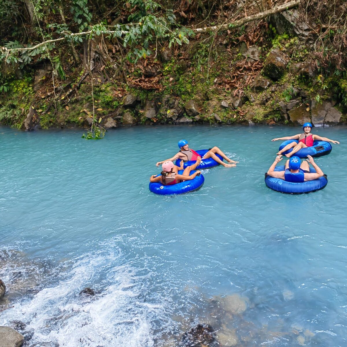 A group of people tubing in Rio Celeste