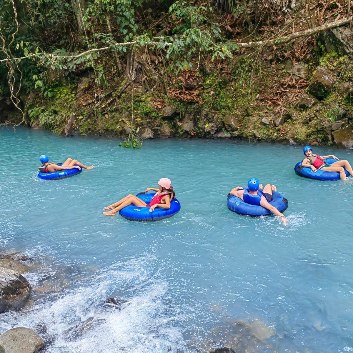4 people riding a tube in rio celeste