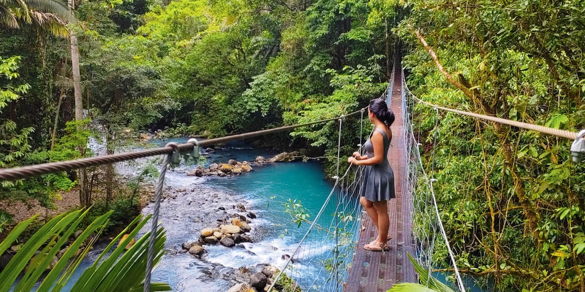A girl on the Katiras Hanging Bridges, below you can see the rio celeste