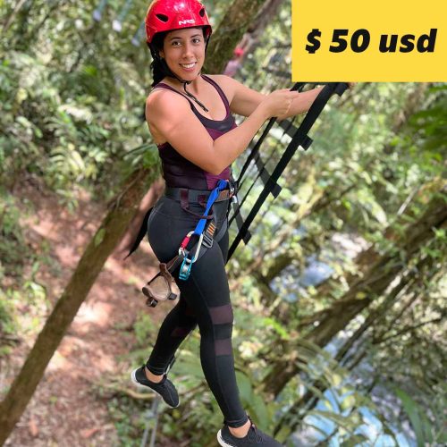 A woman wearing a harness and helmet zip-lining through a Rio Celeste forest with a price tag of $50 USD superimposed on the image.