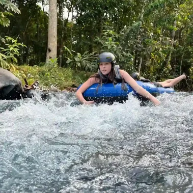 Person tubing in Rio Celeste, wearing a helmet and life vest.