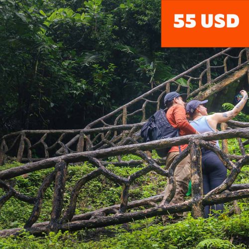 Two people capturing a selfie on a wooden bridge in the lush forest of the Rio Celeste hiking trail. An orange price tag reads "55 USD" in the top right corner. Two people capturing a selfie on a wooden bridge in the lush forest of the Rio Celeste hiking trail. An orange price tag reads "55 USD" in the top right corner.